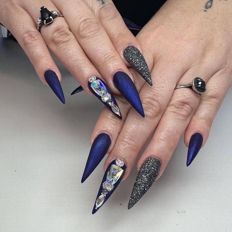 Navy stiletto nails with crystal clusters and charcoal glitter accents